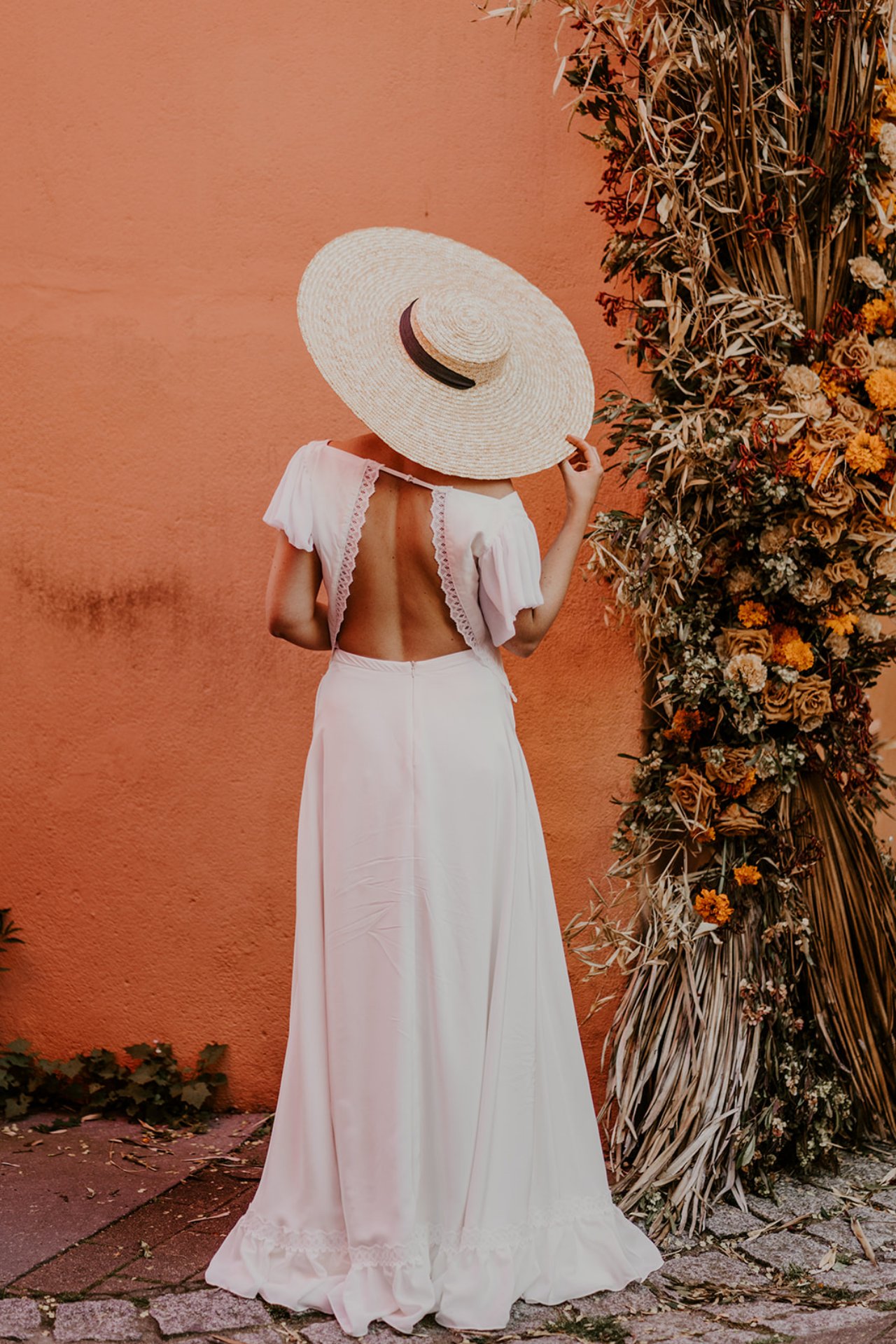 Très belle robe de mariée dos nu avec son chapeau de paille.