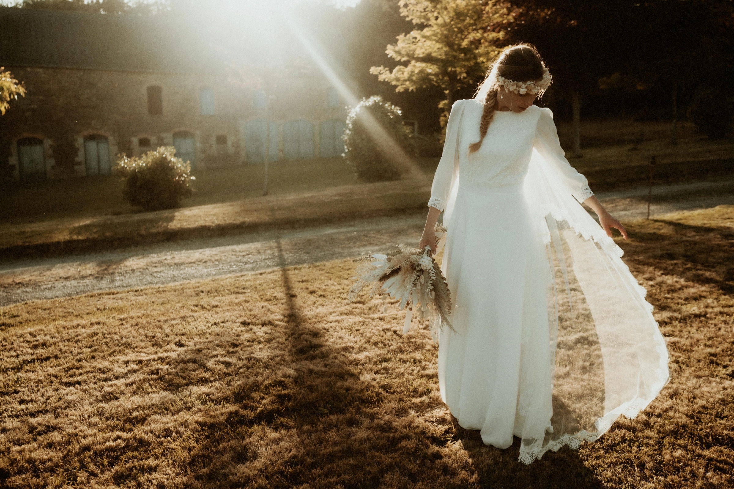 Margaux en robe de mariée, elle porte le voile anémone.