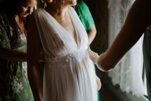 Détails exquis d'une robe de mariée sur mesure en dentelle délicate, mettant en valeur l'élégance et le raffinement.