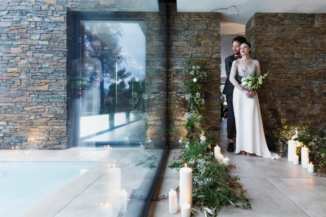 Moment émouvant du couple marié au cœur d'une végétation hivernale, incluant de la mousse, éclairée par des bougies, symbolisant l'amour et la beauté de ce jour spécial.